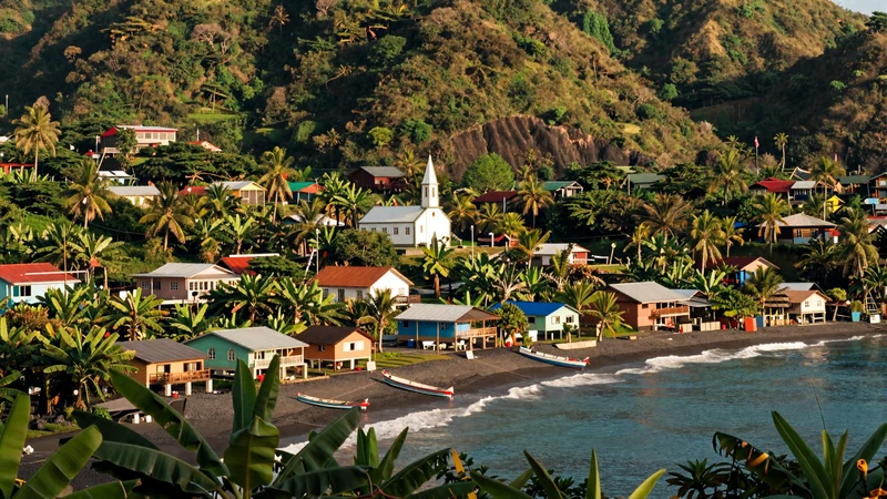 Scenic Vincentian village with colorful houses, a small church, and tropical hillside overlooking the Caribbean coast