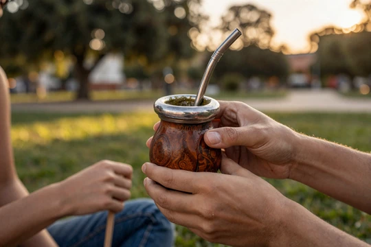 Traditional Uruguayan mate gourd being shared between a couple, symbolizing the intimate bonding tradition central to Uruguayan dating culture